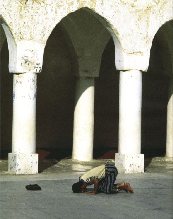 Homme priant dans la cour dune mosqu&eacute;e en Malaisie,             photographie D.R.
